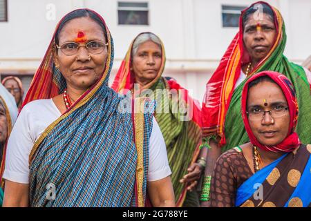 Nahaufnahme eines Porträts von vier nachdenklichen indischen hindu-Weibchen mit bunten Saris, die auf den Sonnenaufgang warten, Kanyakumari, Tamil Nadu, Indien Stockfoto