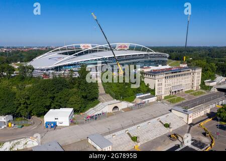 14. Juni 2021, Sachsen, Leipzig: Zwei Krane stehen in der Red Bull Arena. Das Heimgelände von RB Leipzig wird umgebaut. Die Zuschauerkapazität erhöht sich von 42,558 auf 47,069 im Stehen und Sitzen. Die Außenseite des Stadions ist von einer schalldichten Fassade umgeben. Der Damm des ehemaligen Zentralstadions, das die Arena umfasst, wurde hinter dem historischen Glockenturm aufgeschnitten, um Platz für einen neuen Eingang zu schaffen. RB Leipzig investiert bis 2022 gut 60 Millionen Euro in den Umbau. (Luftaufnahme mit Drohne) Foto: Jan Woitas/dpa-Zentralbild/ZB - WICHTIGER HINWEIS: Gemäß den Vorschriften der t Stockfoto