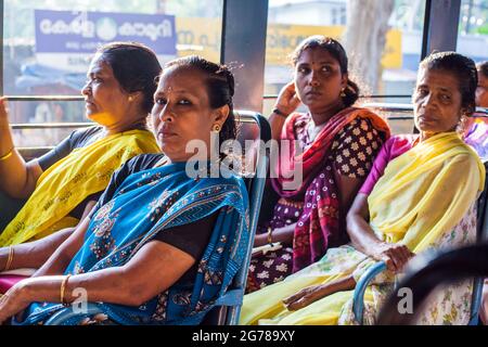 Vier indische Fahrgäste mit bunten Saris im öffentlichen Bus, Kovalam, Kerala, Indien Stockfoto