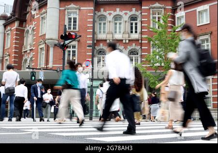 Tokio, Japan. Juli 2021. Pendler überqueren am Montag, den 12. Juli 2021, eine Straße vor dem Bahnhof Tokio in Tokio. 502 Menschen wurden in Tokio mit dem neuen Coronavirus infiziert, und Tokio trat am 12. Juli erneut in den Notstand COVID-19 ein. Quelle: Yoshio Tsunoda/AFLO/Alamy Live News Stockfoto