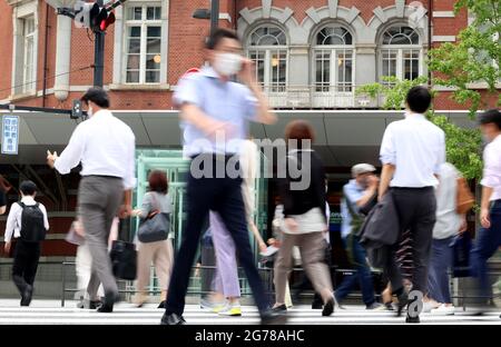 Tokio, Japan. Juli 2021. Pendler überqueren am Montag, den 12. Juli 2021, eine Straße vor dem Bahnhof Tokio in Tokio. 502 Menschen wurden in Tokio mit dem neuen Coronavirus infiziert, und Tokio trat am 12. Juli erneut in den Notstand COVID-19 ein. Quelle: Yoshio Tsunoda/AFLO/Alamy Live News Stockfoto