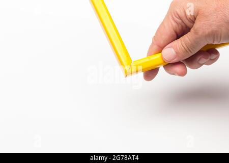 Hand, Finger und verschiedene Farben; Buntstifte, voller Bereich; farbige Winkel, die von der Hand eines Erwachsenen gehalten werden Stockfoto