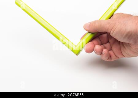 Hand, Finger und verschiedene Farben; Buntstifte, voller Bereich; farbige Winkel, die von der Hand eines Erwachsenen gehalten werden Stockfoto