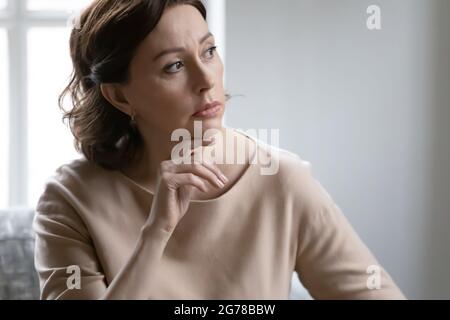 Nachdenkliche reife kaukasische Frau schauen im Ferndenken Stockfoto