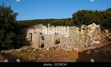 Ionische Inseln, Ithaca, Insel Odysseus, nordwestlich, Bergdorf Exogi, Ruinen eines einzigen stehenden Steinhauses, dahinter Wald, blauer Himmel Stockfoto