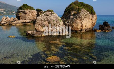 Ionische Inseln, Zakynthos, südlich der Stadt Zakynthos, Banana Beach, kleine Felsen vor dem Meer, bewachsen, meergrün und kristallklar, kleine Felsen sichtbar unter Wasser Stockfoto