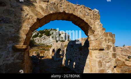 Ionische Inseln, Zakynthos, Berg in der Nähe von Zakynthos Stadt, Monte Yves, Kloster auf dem Gipfel, Panagia Skopiotissa, 15. Jahrhundert n. Chr., steht auf den Ruinen eines antiken Artemis-Tempels, himmelblau, Blick durch Backsteinbögen zu anderen Gebäuden des Klosters Stockfoto