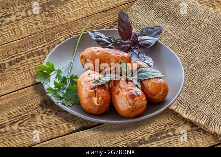 Gegrillte Würstchen auf dem Teller und Holzbretter. Stockfoto
