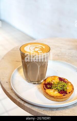 Latte- und Himbeer-Tannennusstarte im WatchHouse-Café, Bermondsey Steet, London, Großbritannien Stockfoto