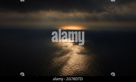 Zakynthos, Paralia Navagio, Shipwreck Beach, Sonnenuntergangsstimmung, Wolken am Himmel, Sonnenreflexe am Wasser, Himmel mit grauen und schwarzen Wolken Stockfoto