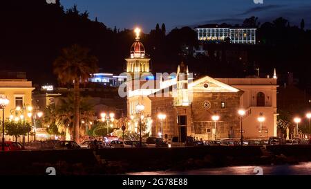 Zakynthos, Stadt Zakynthos, Nachtaufnahme, Abendaufnahme, Kirche Agios Nikolaos von Molos und Kirchturm Agias Triadas, beleuchtet, Straßenbeleuchtung, Hotel beleuchtet am Hang mit einem Hintergrund von min Stockfoto