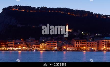 Zakynthos, Zakynthos City, Nachtaufnahme, Abendaufnahme, Ausschnitt der nächtlichen Skyline von Zakynthos City, Wasser im Vordergrund, Gebäude und Agias Triadas Kirche in der Mitte, dunkler Burghügel im Hintergrund, blauer Abendhimmel Stockfoto