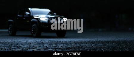 Schwarzes SUV, das nachts im Panorama-3d-Rendering der Stadt geparkt wurde Stockfoto