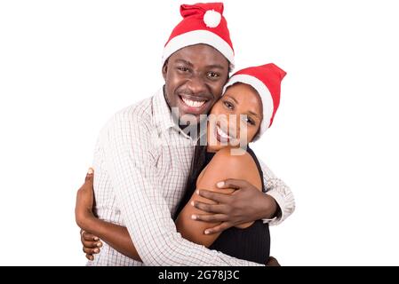 Konzept von Liebe und Urlaub - glückliches Paar trägt weihnachtsmütze auf Kopf küssen auf weihnachtsfeier Stockfoto