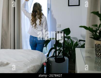 Junge Frau auf der Straße kommt in ihrem Hotelzimmer an Stockfoto