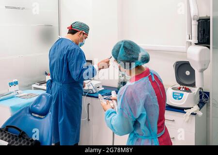 Arzt und Krankenschwester tragen Gesichtsmaske und Schutzausrüstung arbeiten in der medizinischen Klinik. Stockfoto