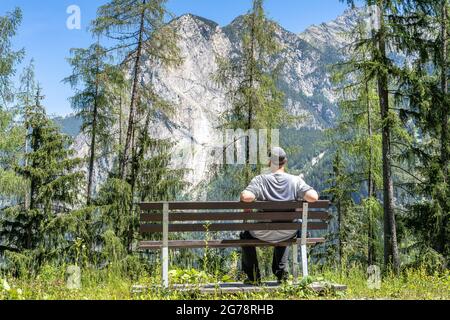 Europa, Österreich, Tirol, Ötztal Alpen, Ötztal, Wanderer sitzt auf einer Bank und schaut auf die Achplatte Stockfoto