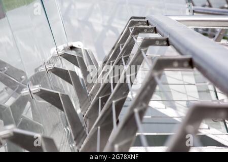 Fußgängerbrücken-Geländer mit Stahlkonstruktion und rahmenlosen Befestigungen für Nahaufnahme-Glasschließer, Befestigungssystem und Aufhängungsstrukturen. Stockfoto