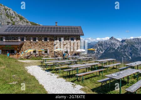 Europa, Österreich, Tirol, Stubaier Alpen, Bergwanderer auf der sonnigen Terrasse der Starkenburger Hütte mit den Serles im Hintergrund Stockfoto