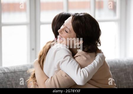 Glückliche Erwachsene Tochter und alte Mutter umarmen zu Hause Stockfoto