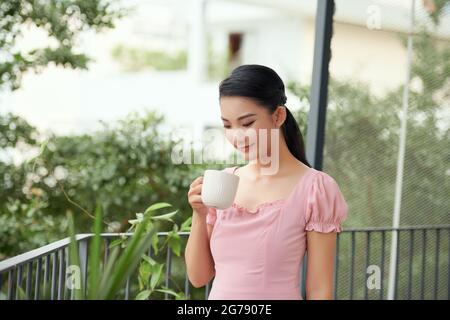 Frau mit Kaffee Garten auf Balkon im Sommer. Stockfoto