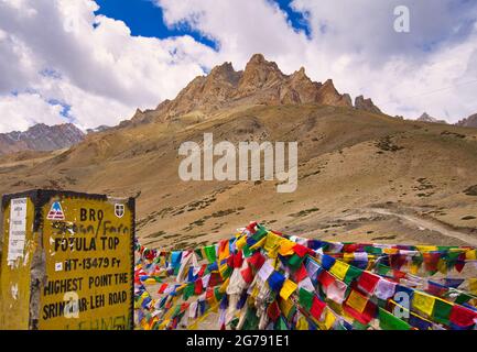 Wunderschöne Naturkulisse. Gelbe Erde Bergkette. Bunte Flaggen. Blick auf zwischen Lamayuru und Kargil in Ladakh, Jammu und Kaschmir, Indien, Juni Stockfoto