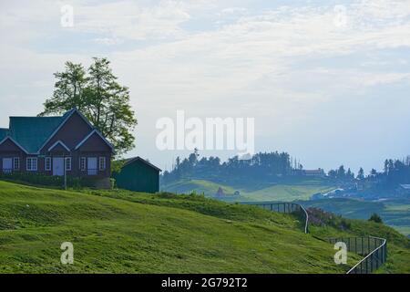 Morgenansicht einer Farm auf den Hügeln von Gulmarg. Nebel umgibt und viele Häuser, Jammu und Kaschmir, Indien. Juni 2018. Stockfoto