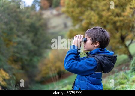 Europa, Deutschland, Baden-Württemberg, Stuttgart, Junge blickt durch ein Fernglas auf die Landschaft Stockfoto