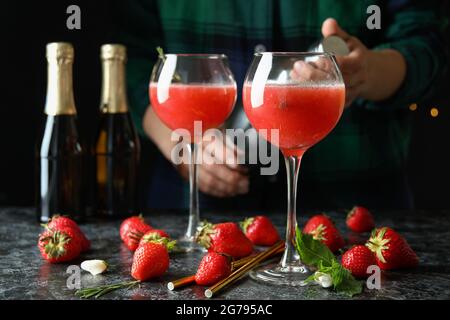 Konzept der Herstellung von Rossini-Cocktails vor dunklem Hintergrund Stockfoto