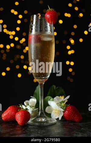 Konzept eines köstlichen Getränks mit Rossini-Cocktail vor dunklem Hintergrund mit verschwommenem Licht Stockfoto