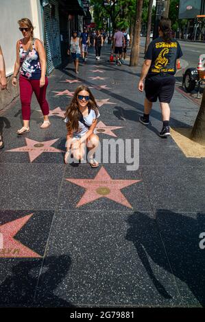 Ein kaukasisches Mädchen, 15-20 Jahre auf dem Sunset Strip in Holywood vor einem Stern, Los Angeles, Kalifornien, USA Stockfoto