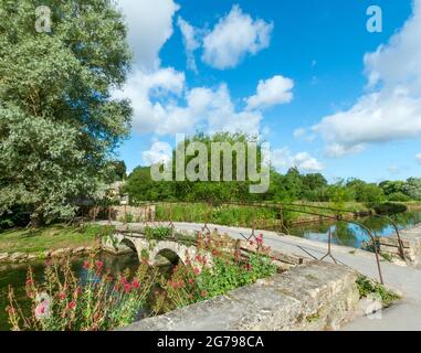 Großbritannien, GL Gloucestershire, Bibury in der Nähe von Cirencester, Brücke über den Fluss Coln, historische Steinbrücke, Fußweg zur Arlington Row. Der Künstler und Schriftsteller William Morris nannte Bibury "das schönste Dorf in England". Stockfoto
