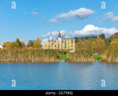 Deutschland, Baden-Württemberg, Illmensee, Blick über den Illmensee zum Kath. Pfarrkirche Mariä Himmelfahrt. Der Illmensee liegt im FFH-Gebiet 8122-342 'Pfrunger Ried und Seen bei Illmensee'. Im Naturschutzgebiet liegt das eiszeitliche Seeplateau mit dem Illmensee, dem Ruschweiler See und dem Volzer See. Stockfoto