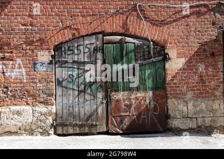 Alte Scheunentüren, mit abblätternder Farbe, mit zwei großen Metallschlössern darauf. Muster Stockfoto