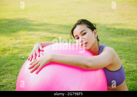 Glücklich schöne junge Frauen mit feinem Ball macht Übungen im Park.Konzept eines gesunden Lebensstils Stockfoto