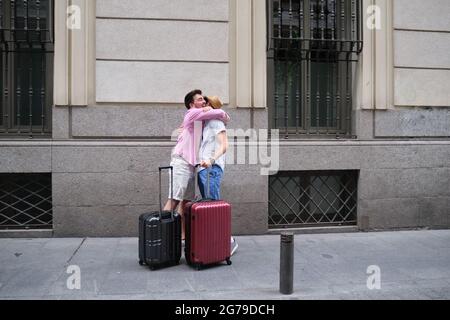 Ein paar glückliche Touristen umarmen sich, wenn sie nach langer Zeit wieder begegnen. Wiedervereinigung von zwei Freunden. Stockfoto