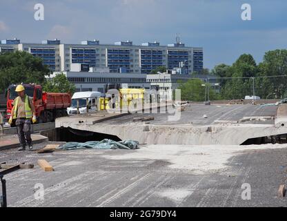 12. Juli 2021, Brandenburg, Potsdam: Ein Arbeiter geht an einem der Segmente der alten Brücke auf der Baustelle der Hochbrücke der Landstraße L40 Nuthestraße entlang. Aufgrund von Platzmangel werden die rund 30 Meter langen und 600 Tonnen schweren Abschnitte aus Beton und Verstärkungsstahl in mehreren Teilschritten hinter dem Abutment der Friedrich-Engels-Straße mittels Hydraulik gezogen, wo der alte Überbau zerkleinert und abtransportiert wird. Die Sanierung der Hochstraßenbrücke soll im Oktober 2022 abgeschlossen werden. Foto: Soeren Sache/dpa-Zentralbild/ZB Stockfoto