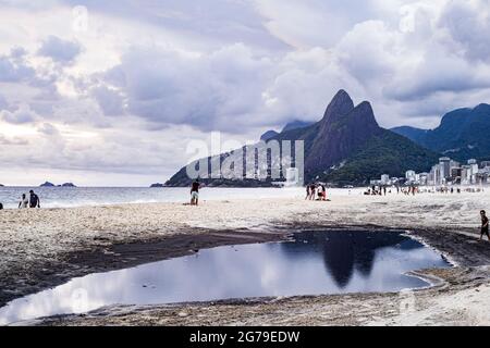 Großer Wasserpuddle nach Regen, der den Berg der zwei Brüder (Dois Irmaos) am Strand von Ipanema/Leblon in Rio de Janeiro, Brasilien widerspiegelt. Leica M10 Stockfoto