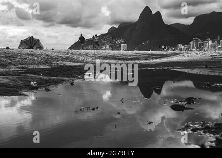 Großer Wasserpuddle nach Regen, der den Berg der zwei Brüder (Dois Irmaos) am Strand von Ipanema/Leblon in Rio de Janeiro, Brasilien widerspiegelt. Leica M10 Stockfoto