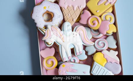 Schöne Lebkuchenkekse für Kinderparty in Form eines Einhorns und Süßigkeiten, flach liegend. Stockfoto