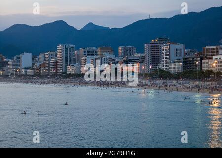 Ein magischer Ort: Die Menschen applaudieren, wenn die Sonne am Arpoador-Felsen untergeht, mit Blick auf den Strand von Ipanema und die Berge von Morro Dois Irmaos und Leblon im Hintergrund. Kamera: Leica M10 Stockfoto