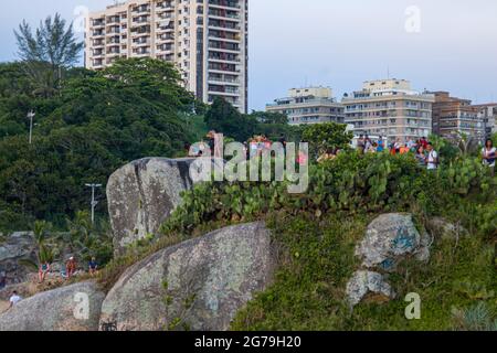 Ein magischer Ort: Die Menschen applaudieren, wenn die Sonne am Arpoador-Felsen untergeht, mit Blick auf den Strand von Ipanema und die Berge von Morro Dois Irmaos und Leblon im Hintergrund. Kamera: Leica M10 Stockfoto