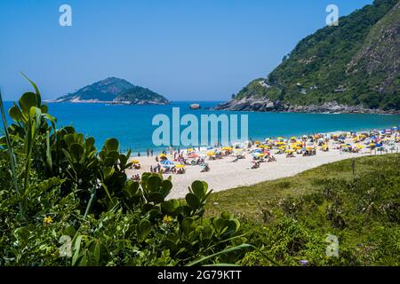 Strandleben am Strand von Prainha, westlich der Stadt Rio de Janeiro, am Bergwald in Brasilien Stockfoto