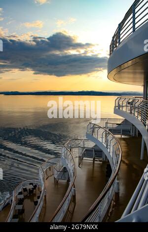 Sonnenaufgang oder Sonnenuntergang vom Achterdeck eines Kreuzfahrtschiffs über dem Ozean, auf dem die Nord- oder Ostsee durchquert wird. Stockfoto