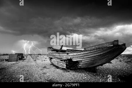 Dungeness Beach Wracked boat on the Shingle Beach with Lightning Storm Dungeness Nature Reserve Kent England GB Europa Stockfoto