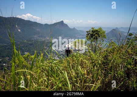 Ein Mann mit Hut, der den malerischen Blick auf den Strand von Ipanema und die Lagoa Rodrigo de Freitas vom Gipfel des Dois Irmaos Two Brothers Mountain in Rio de Janeiro, Brasilien, genießt Stockfoto