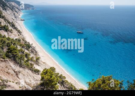 Lefkada, Griechenland. Abgelegener weißer Egremni-Strand mit einsamem Luxus-Yacht-Boot an der türkisfarbenen Bucht am Ionischen Meer Stockfoto