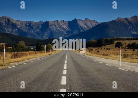 Gerade Straße von La Quillane nach Les Angles (Frankreich). Im Hintergrund einige Berge aus den Pyrenäen Orientales Stockfoto