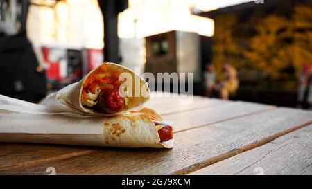 Hot Dog in Pita Brot auf einem Holztisch. Street Food im City Food Court Stockfoto