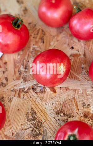 Vertikale Schuss viele rote Tomaten auf Holztisch. Stockfoto